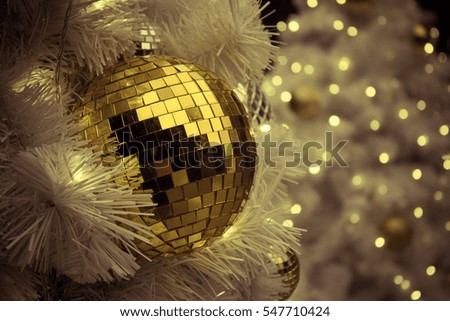 Golden disco ball on white christmas tree with blur bokeh light
