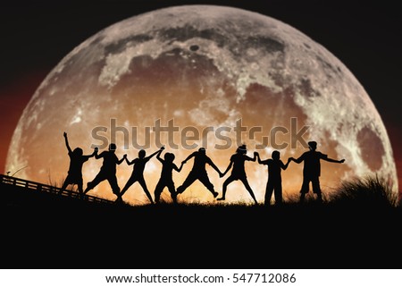Silhouette of people jumping friendship Happiness on a  the full moon background .Ã?Â  Elements of this image furnished by NASA.