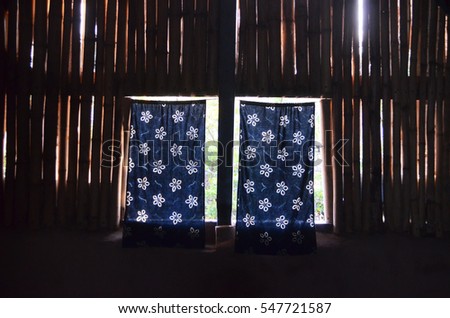 bamboo wall and windows and blue curtains photo taken from dark room with natural sun light