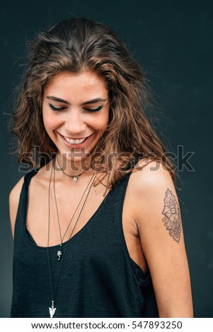 Pretty young woman with a new tattoo, satisfied, posing for camera