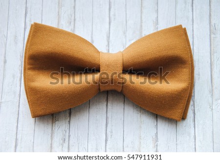 Bow tie on a wooden background. Accessory for formal dress. Men's casual. Men's and women's accessories. Men's and women's bowtie. Royalty-Free Stock Photo #547911931