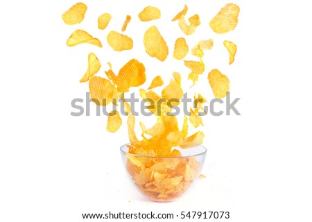 Flying potato crisps over a bowl isolate on white background. Royalty-Free Stock Photo #547917073