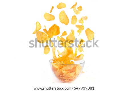 Crisps hovering over a bowl on a white background Royalty-Free Stock Photo #547939081