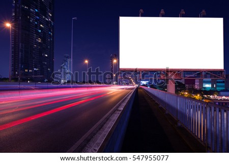 Blank billboard on light trails, street and urban in the night - can advertisement for display or montage product or business. Royalty-Free Stock Photo #547955077
