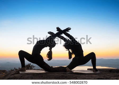 Two women, yoga, mountain sunset.