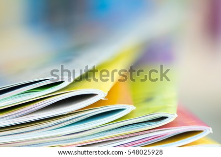 Close up edge of colorful magazine stacking with  blurry bookshelf background for publication and publishing concept , extremely DOF  Royalty-Free Stock Photo #548025928