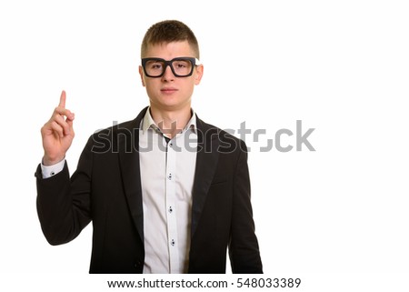 Studio shot of young businessman pointing finger up isolated against white background