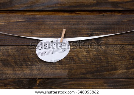 Paper heart with notes on the clothespin with rope on a wooden background