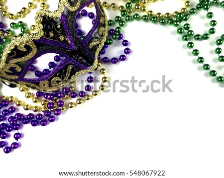 Mardi Gras beads and mask on a white background with copy space