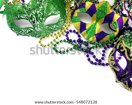 Mardi Gras masks and beads on a white surface with copy space