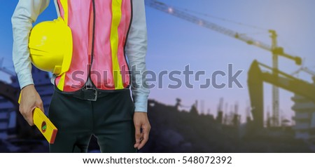 engineer yellow helmet for workers security with recording. on a notebook. on the background of a new high-rise apartment buildings and construction cranes.for banner website.vintage tone.