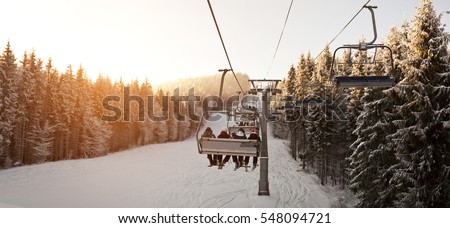 People are lifting on ski-lift in the mountains Royalty-Free Stock Photo #548094721