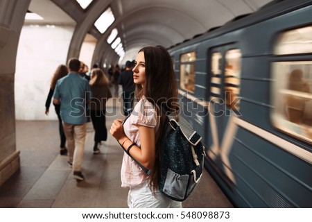 Back view portrait of young girl with backpack waiting the train in metro. Royalty-Free Stock Photo #548098873
