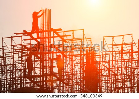 silhouette construction team working on high ground over blurred background sunset pastel for industry background.