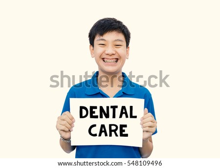 Asian teen beautiful smile teeth brace dental holding paper DENTAL CAREÂ� on isolate background.