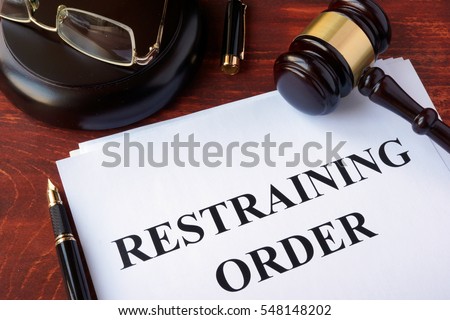 Restraining order and gavel on a table. Royalty-Free Stock Photo #548148202