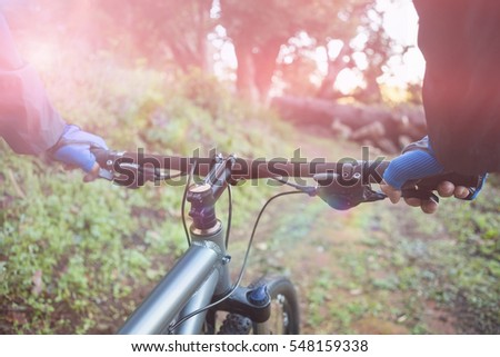 Close-up of male mountain biker riding bicycle in forest