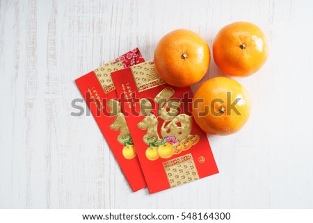 Chinese new year festival decorations, ang pow or red packets and mandarin oranges, golden Chinese letter means luck