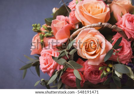 Vivid arrangement of rose flowers and baby bloom eucaliptum against gray background. Studio photography. Close up. Selective focus