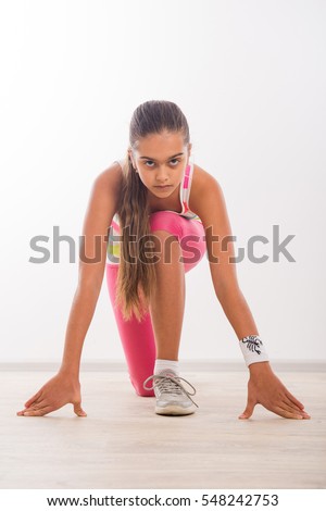 Sports Running girl. Beautiful teenage girl doing exercises, girl on the carpet at home exercise. Physical exercise for schoolchildren.  Female athlete in position ready to run.