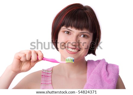 Beautiful girl holding up a toothbrush that contains tooth paste. Young Woman cleaning her teeth.