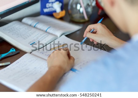 Teenager boy doing homework on his desk at home Royalty-Free Stock Photo #548250241
