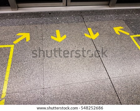 Yellow arrow sign indicate on marble floor, On the subway

