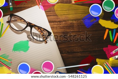 Frame of art supply against eye glasses on book with copy space