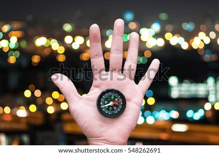 Compass in hand with Bokeh light background