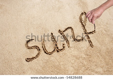 surf handwritten in sand on a beautiful beach