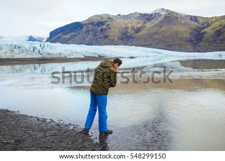 man looking into lake water in Iceland