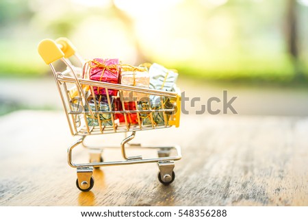 Small shopping cart / trolley on wood table for shopping online with copyspace nature background, Technology online marketing and business trading concept.