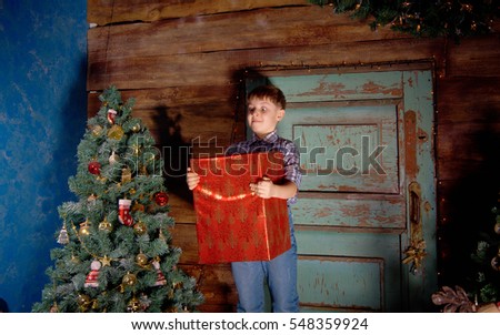 Happy little Boy decorate Christmas tree in beautiful living room with traditional fire place. 
