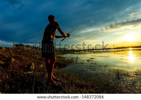 Fishing at dusk ,fishermen walking on bank at twilight .