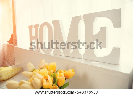 Wooden letters created in word Home against the window. Image for the background for the text.
