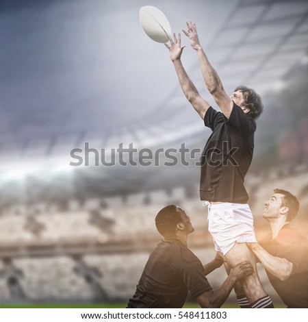 Rugby fans in arena copy space against rugby players jumping for line out 3d Royalty-Free Stock Photo #548411803