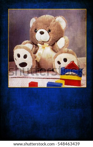 Greeting card for small children.  Blue background with square photo of teddy bear and building blocks on vertical image.  Digital texture layers on image. Copy space in lower part of picture.