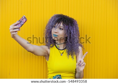 Young woman with afro hair taking a picture of herself