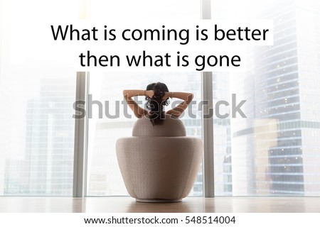 Young model sitting in armchair, hands crossed behind head, looking panoramic glass wall at city after waking up at morning. Photo with motivational text " What is coming is better then what is gone"