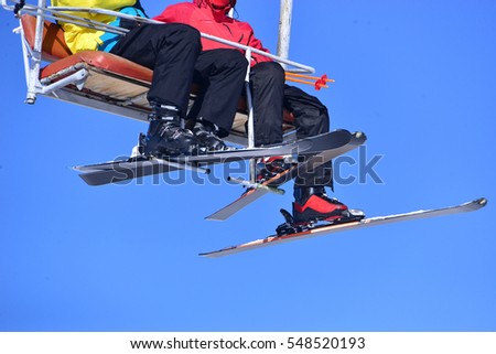  sit on the ski lift and waiving hand with sky 