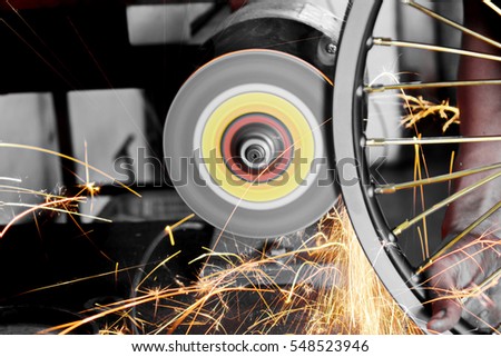 Repair technicians are using a grinding wheel motorcycle. /Cause differences in color.