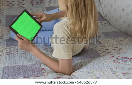 Woman at home relaxing reading on the tablet computer