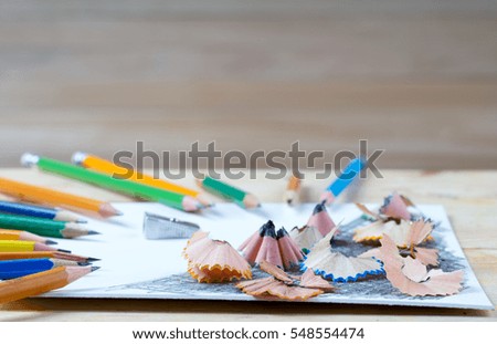 Pencil sharpener shavings on the white paper. Back to school. Copy space.