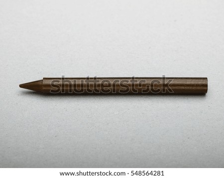 Brown wax crayon on gray background