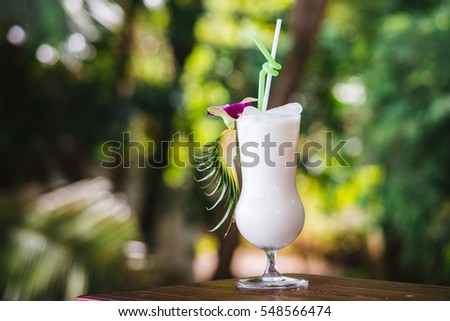 Pina Colada Cocktail with ice on the background of the tropics. A cold drink in the tropics