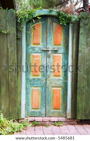 Antique painted teak wood doors in a garden