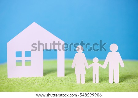 Paper cut of family on green grass background
