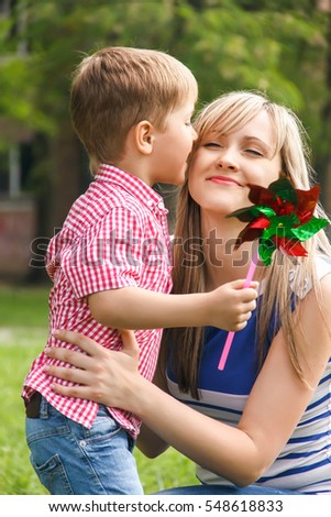Happy little boy with his mother in the park enjoying the summer day