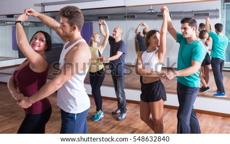 Young sporty girls and men learning latino steps Royalty-Free Stock Photo #548632840