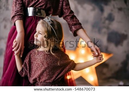 mother and daughter in the image of the queen and princess dresses in the colors of Marsala with a long train in the loft